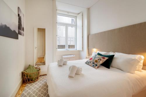 um quarto com uma grande cama branca e uma janela em Modern 1BDR in Downtown Lisbon by LovelyStay em Lisboa
