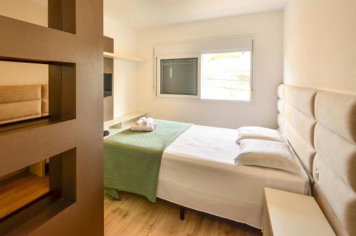 a small bedroom with a bed and a window at Jurerê para 6 hóspedes a 2 quadras da praia N1705 in Florianópolis