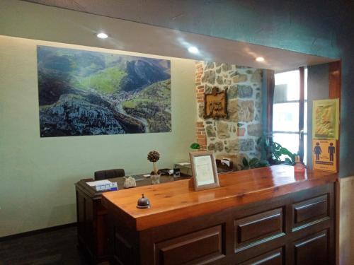 a large painting on a wall above a wooden desk at Hotel Rural Cabrales in Carreña de Cabrales 