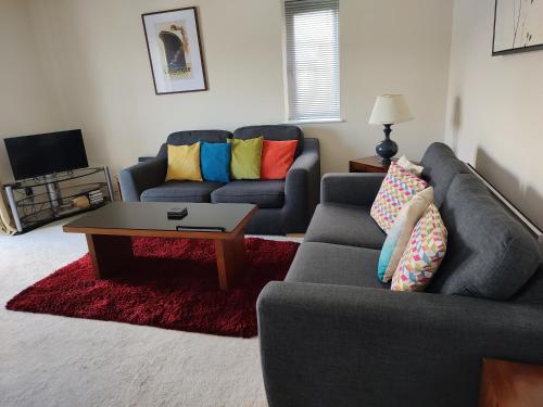 a living room with two couches and a coffee table at Baystays Scenic View in Swansea
