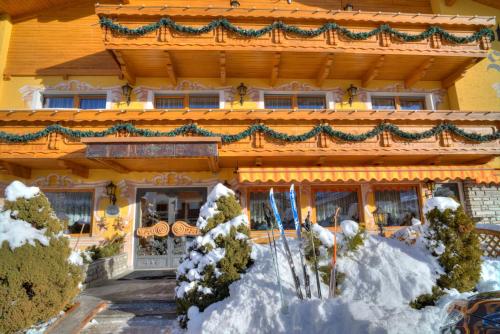 a building with snow in front of it at Hotel Serles Superior in Dobbiaco
