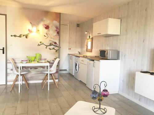 una piccola cucina con tavolo e una sala da pranzo di Studio Les Remparts de Kerjouanno ad Arzon