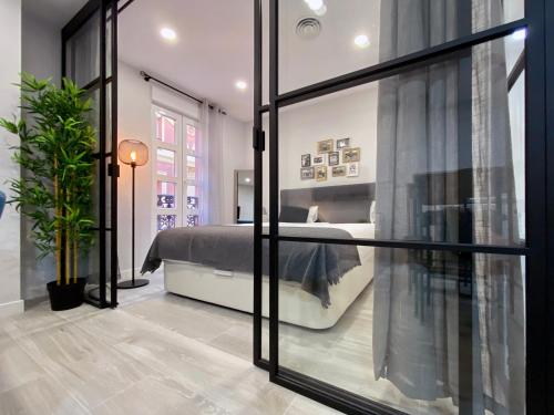 a bedroom with a bed and a large glass window at Charming Madrid Styles in Madrid