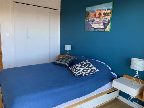 um quarto com uma cama com uma parede azul em Plage à pied à 3 mns em La Seyne-sur-Mer