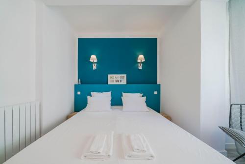 - une chambre avec un grand lit blanc et un mur bleu dans l'établissement Brand new one bedroom heart of Cannes!!, à Cannes