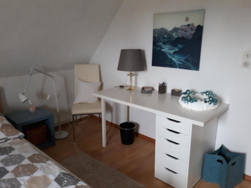 a white desk in a room with a bed at Kandelblick in Teningen
