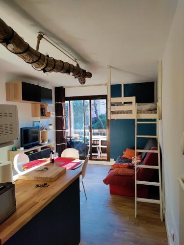 une chambre avec un bureau et une chambre avec des lits superposés dans l'établissement studio Seignosse Océan (plages et commerces à pied), à Seignosse
