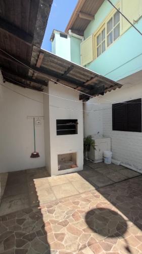 an outdoor patio with a fireplace in a house at Casa na Praia, Torres RS in Torres