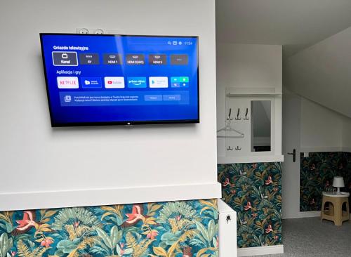 a flat screen tv hanging on a wall in a room at Pokoje Gościnne u Klimosza in Pogwizdów