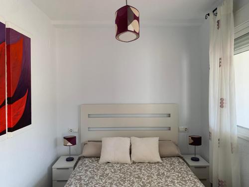 una camera bianca con un letto con due cuscini di Apartamento a pie de playa a El Portil