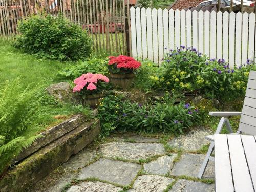 a garden with two potted plants and flowers at Skjerping gård in Lonevåg
