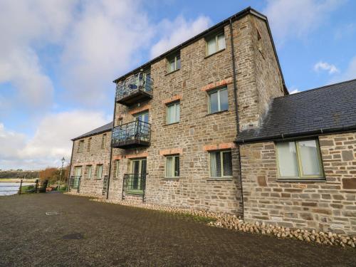 a brick building with a balcony on the side of it at Flat 2 in Pembroke