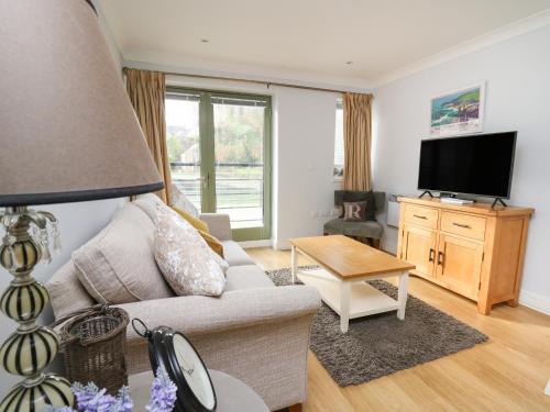 a living room with a couch and a tv at Flat 2 in Pembroke