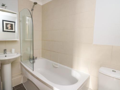 a bathroom with a tub and a sink and a toilet at Flat 2 in Pembroke