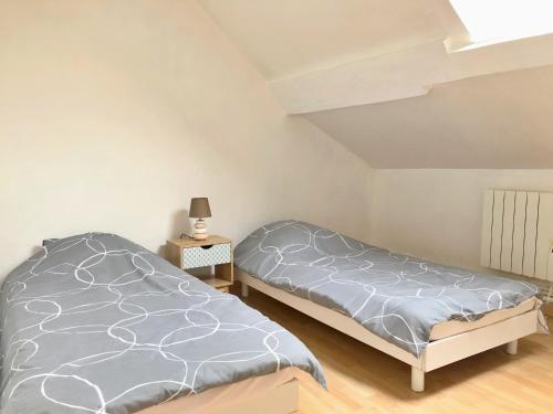 une chambre avec deux lits et une lampe sur une table dans l'établissement Duplex 2 chambres 4 personnes - Bourg de Saclay, à Saclay