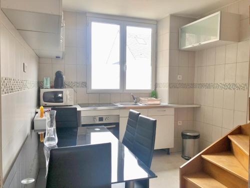 une cuisine avec une table, un évier et une fenêtre dans l'établissement Duplex 2 chambres 4 personnes - Bourg de Saclay, à Saclay