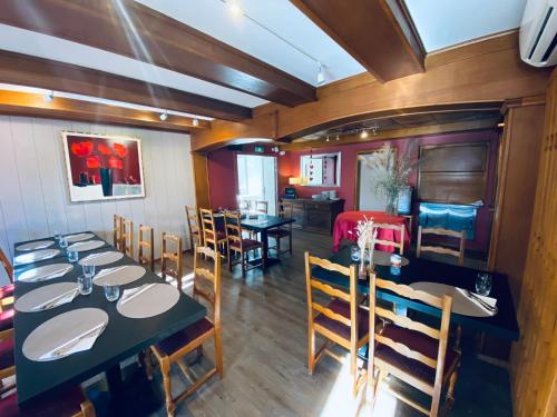 a dining room with tables and chairs in a room at Logis Hôtel Restaurant Au Lion Rouge in Bartenheim