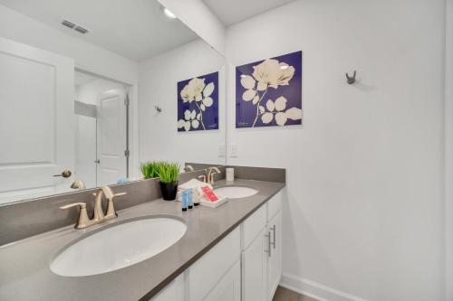 uma casa de banho com 2 lavatórios e um espelho em 1030 Splash Shot Place em Kissimmee