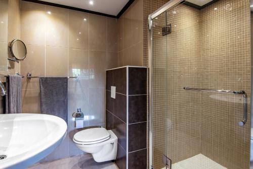 une salle de bain avec un lavabo, des toilettes et une douche dans l'établissement Modern appartement op resort Seru-Coral 4 pers 2 slpk met een groot zwembad, à Willemstad