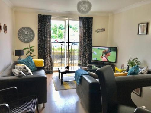 a living room with couches and a flat screen tv at Swanning Off Whitby with Parking in Whitby