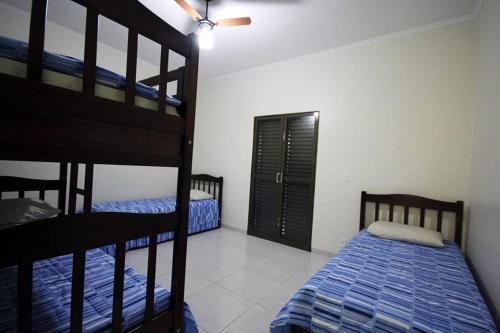 a bedroom with two bunk beds and a closet at Recanto Vale do Sol in Olímpia