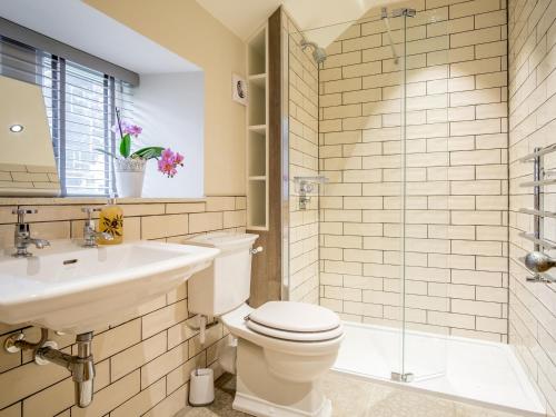 une salle de bain avec toilettes, lavabo et douche dans l'établissement School Cottage, à Purmerend