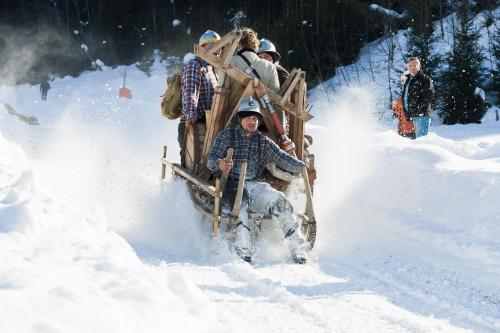 a group of people riding a sleigh in the snow at House of Hütter - Wachtelhof & SPA in Maria Alm am Steinernen Meer
