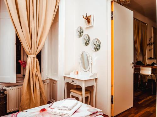 ウィーンにあるヴォーネン イム ヘルツェンフォンウィーンのベッドルーム(ベッド1台、鏡、シンク付)