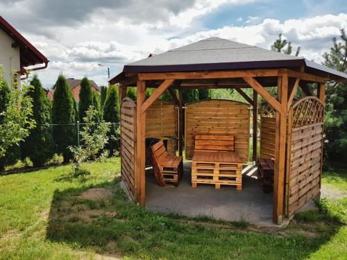 un gazebo in legno con tavolo e sedie in cortile di Przytulne mieszkanie w sercu Kaszub a Wąglikowice
