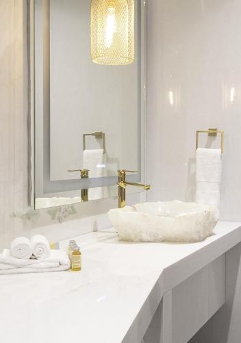 a white bathroom with a sink and a mirror at L Hotel Perla Boutique in Puebla
