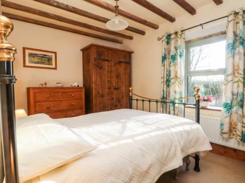 a bedroom with a bed and a window at 2 Oddfellows Cottages in Hope