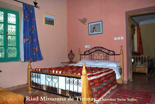 ein Schlafzimmer mit einem Bett in einem Zimmer in der Unterkunft Riad Mimouna De Timnay in Aguelmous
