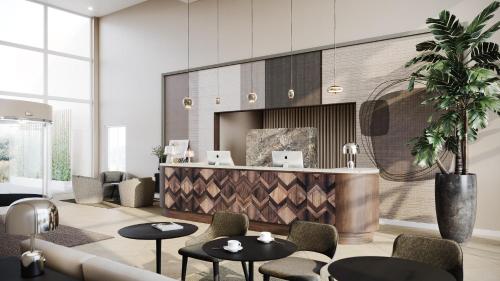 a lobby with a reception desk and tables and chairs at Hotel de Schelde in Cadzand-Bad