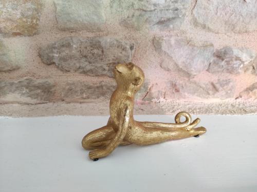 a gold figurine of a cat sitting on a table at Les Meublés des Pierres Dorées - Gite de charme pour groupe in Theizé