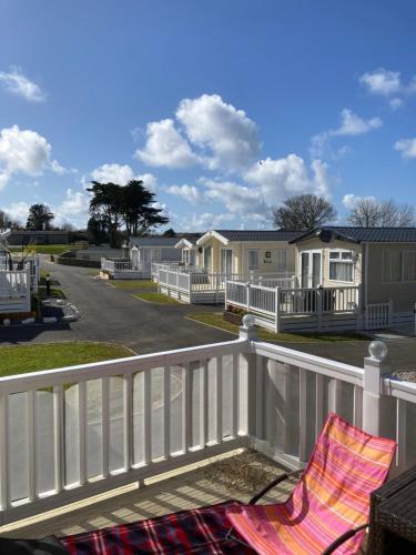 a rocking chair sitting on a balcony with houses at Mollys Retreat pet friendly three bed caravan with small garden Newquay Bay Resort Quieter area of park in Newquay