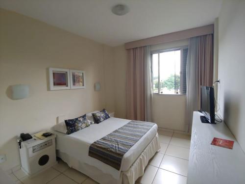 a hotel room with a bed and a television at San Michel Palace Hotel in Taubaté