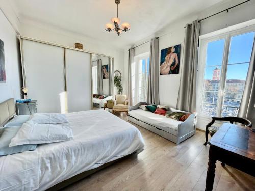 - une chambre avec un lit, un canapé et des fenêtres dans l'établissement Spacious 3 BR flat Nice center - magnificent view, à Nice