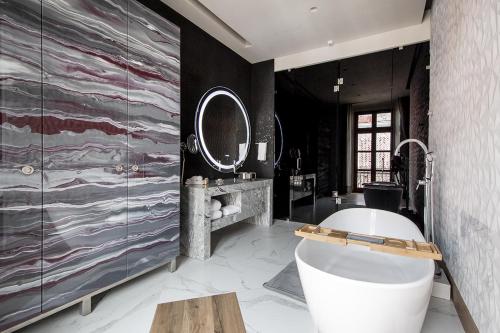a bathroom with a large tub and a large mirror at L Hotel Perla Boutique in Puebla