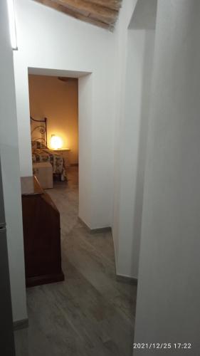 a hallway with white walls and a room with a bed at La casa di Lisa in Suvereto
