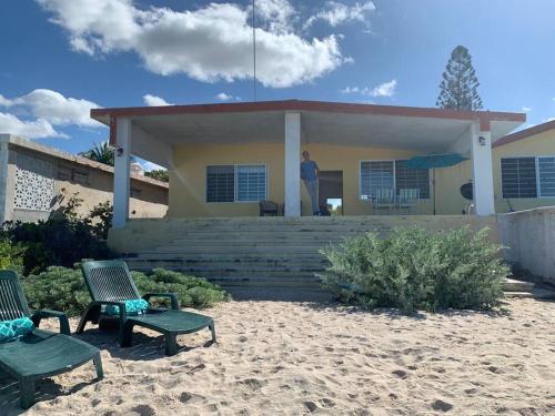 a man standing on the porch of a house at La Casa Amarilla Frente al Mar in Chelem