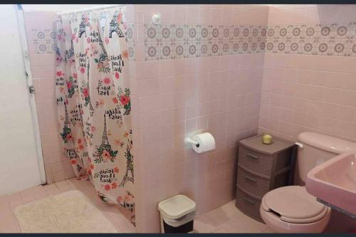 a bathroom with a toilet and a shower curtain at La Casa Amarilla Frente al Mar in Chelem