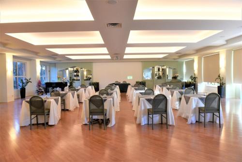 a banquet hall with white tables and chairs at Brianteo Hotel Residence and Restaurant in Burago di Molgora