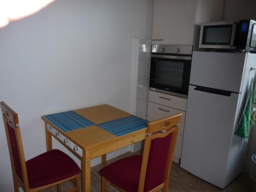 a small kitchen with a small table and a refrigerator at Wohnung "Niedersachsen" in Hohenhameln