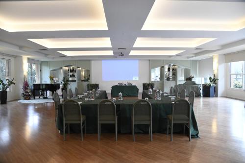 a banquet hall with tables and chairs and a piano at Brianteo Hotel Residence and Restaurant in Burago di Molgora