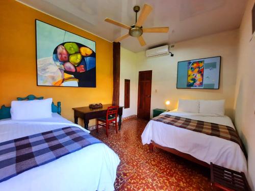 a room with two beds and a painting on the wall at Hotel La Posada del Doctor in León