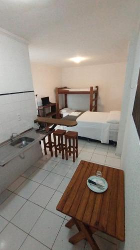 a kitchen with a bed and a table in a room at Flat Schnneider, Hospedagem econômica, empresas, diárias in Taubaté