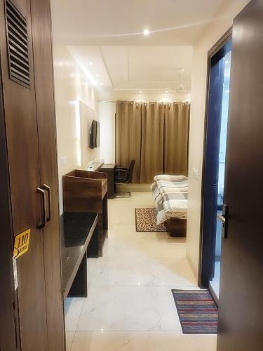 an open door to a room with a bed and a desk at Hotel Luxuria in Ludhiana