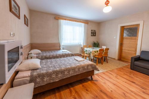 a bedroom with two beds and a dining room at Byczy Rog noclehy na hranici in Králíky