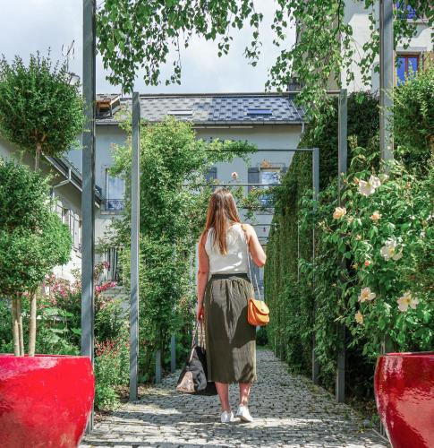 a woman walking down a path in a garden at Le Faucigny - Hotel de Charme & SPA in Chamonix-Mont-Blanc