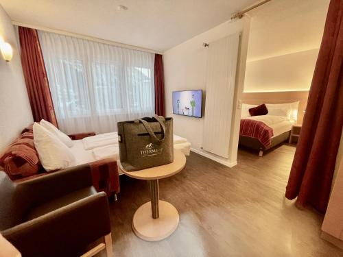 a hotel room with a bag on a table at Therme 51° Hotel Physio & Spa in Leukerbad
